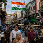 Busy Indian business street and market with the Indian flag flying above shops, traders and pedestrians