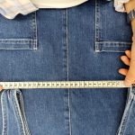 Inspector measuring the waistband of denim jeans during a denim quality control inspection