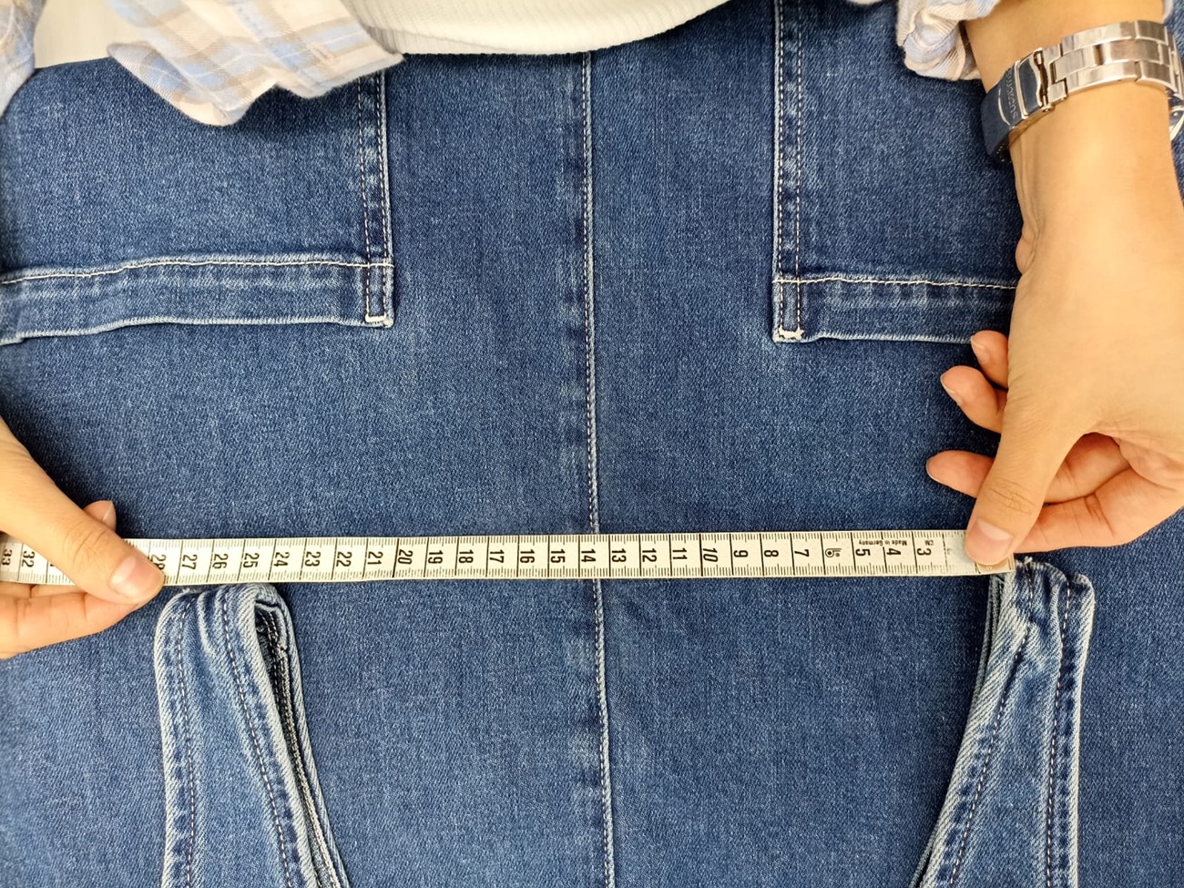 Inspector measuring the waistband of denim jeans during a denim quality control inspection